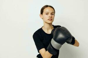 lindo menina dentro Preto Esportes uniforme boxe luvas posando estilo de vida inalterado foto