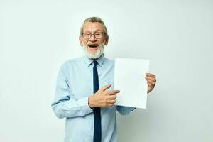 retrato do feliz Senior homem segurando documentos com uma Folha do papel luz fundo foto