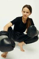 lindo menina boxe Preto luvas posando Esportes ginástica Treinamento foto