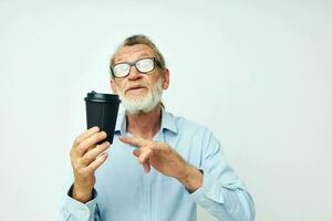 retrato idosos homem com uma Preto vidro dentro dele mãos uma beber isolado fundo foto