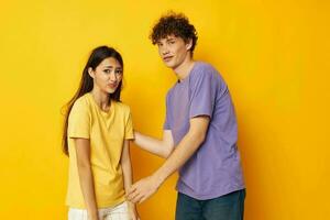 jovem Garoto e menina casual roupas posando emoções palhaçadas amarelo fundo inalterado foto