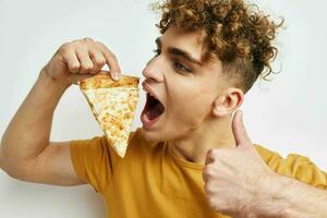 atraente homem comendo pizza posando fechar-se estilo de vida inalterado foto