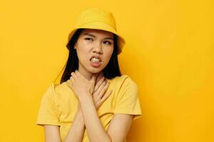 mulher com ásia aparência dentro uma amarelo camiseta e chapéu posando emoções monocromático tiro foto