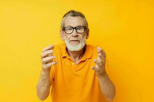 Senior grisalho homem vestindo óculos amarelo camisa posando isolado fundo foto