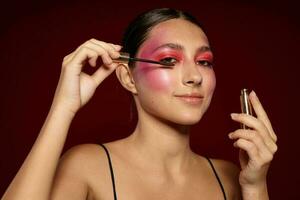 retrato do lindo jovem mulher Rosa face Maquiagem posando atraente Veja pele Cuidado cortada Visão inalterado foto