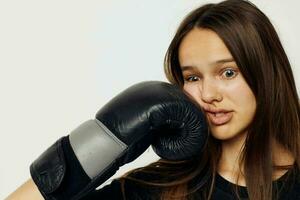 lindo menina dentro boxe luvas soco dentro Preto calça e uma camiseta ginástica Treinamento foto