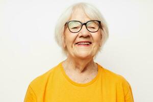 retrato do a velho amigáveis mulher dentro casual camiseta e óculos isolado fundo foto