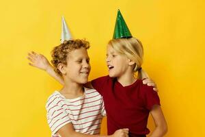 pequeno crianças feriado Diversão com cápsulas em seu cabeça amarelo fundo foto