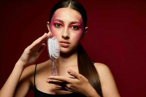 elegante mulher com uma pente brilhante Maquiagem posando Preto jérsei Rosa fundo inalterado foto