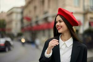 moda mulher retrato sorrir dentes em pé em a rua dentro a cidade fundo dentro à moda roupas com vermelho lábios e vermelho boina, viagem, cinematográfico cor, retro vintage estilo, urbano moda estilo de vida. foto