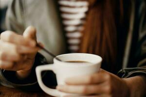 mulher dentro cafeteria mexendo açúcar dentro branco café caneca, outono vibração e caloroso conteúdo para social meios de comunicação, blogueiro foto