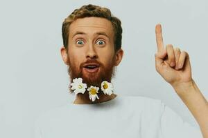 retrato do uma engraçado homem dentro uma branco camiseta com flores margaridas dentro dele barba em uma branco isolado fundo, cópia de lugar. feriado conceito e Parabéns. foto