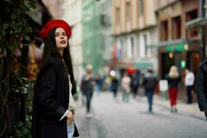 mulher moda modelo anda em em a rua dentro a cidade Centro entre a multidão dentro uma Jaqueta e vermelho boina e jeans, cinematográfico francês moda estilo roupas, viagem para Istambul foto