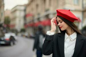 moda mulher retrato sorrir dentes em pé em a rua dentro a cidade fundo dentro à moda roupas com vermelho lábios e vermelho boina, viagem, cinematográfico cor, retro vintage estilo, urbano moda estilo de vida. foto