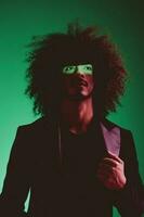 retrato do uma à moda homem dentro uma Jaqueta em uma verde fundo multinacional, cor luz, tendência foto