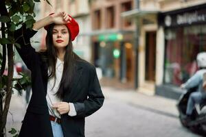 mulher modelo carrinhos em a rua dentro a cidade dentro uma Jaqueta e vermelho boina, cinematográfico francês moda estilo roupas, viagem para Istambul foto