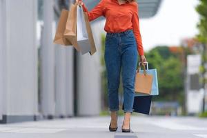 retrato ao ar livre da perna de uma mulher segurando sacolas de compras foto