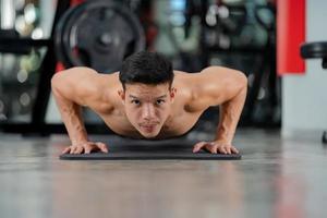 esporte homem treinando fazendo flexões no ginásio de fitness foto