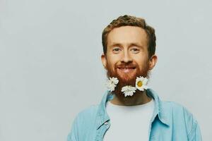 retrato do uma engraçado homem dentro uma branco camiseta com flores margaridas dentro dele barba em uma branco isolado fundo, cópia de lugar. feriado conceito e Parabéns. foto