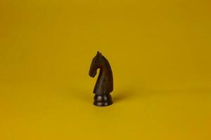 a poder do de madeira xadrez cavalo peça isolado amarelo fundo, usava para sucesso e estratégia conceito foto