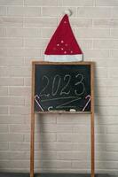 uma Preto ardósia em que a ano 2023 é escrito dentro giz. feliz Novo ano. foto