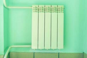 secional radiador do a aquecedor em a parede dentro sala, aquecimento tubos foto