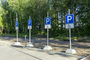 estacionamento sinais para pessoas com deficiências dentro a parque foto