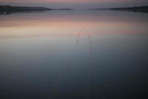 uma névoa sobre a água ao pôr do sol, pôr do sol sobre o lago foto