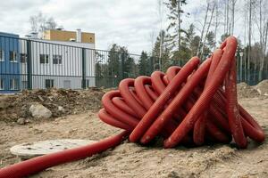 enrolado acima vermelho ondulado PVC tubo para deitado elétrico cabos foto