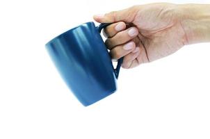 mão segurando a xícara de café azul sobre fundo branco foto