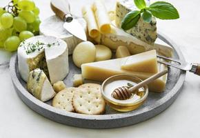 vários tipos de queijo, uvas e mel foto