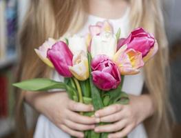 tulipas da primavera nas mãos de uma menina.