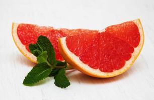 toranja com hortelã e gelo em um antigo fundo de madeira branco foto