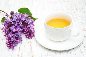 xícara de chá e flores lilás