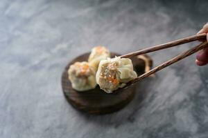chinês cozido no vapor dumplings ou escuro soma dentro bambu vaporizador em Sombrio abstrato fundo foto