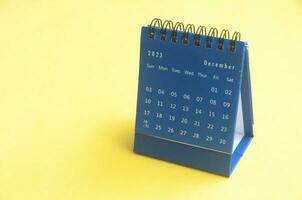 dezembro 2023 azul escrivaninha calendário em amarelo cobrir fundo com Customizável espaço para texto. cópia de espaço e calendário conceito foto