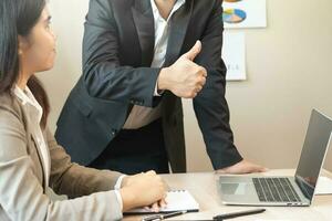 parabenizando, confiança dois colega ásia homem de negocios, mulher encorajar funcionários para feito excelente trabalhar. patrão mostrando polegares acima para Faz muito Boa trabalho. Liderança do equipe apoiar. Confiar em do Supervisor. foto