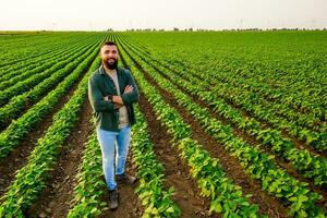 retrato do agricultor quem é cultivar soja. ele é satisfeito com Boa progresso do plantas. agrícola ocupação. foto