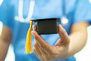 estudo de médico asiático aprende com chapéu de graduação na enfermaria do hospital, conceito de medicina de educação de gênio brilhante inteligente. foto