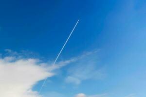 uma privado jato avião vôo com rastros ou vapor trilhas em azul céu foto