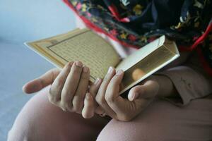 muçulmano mulheres mão lendo Alcorão foto