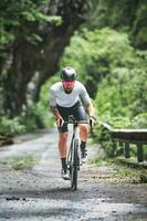 uma ciclista em uma corrida bicicleta em uma montanha estrada foto