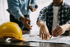 construção e estrutura conceito do engenheiro trabalhando desenhando em projeto encontro para projeto trabalhando com parceiro em modelo construção e Engenharia Ferramentas dentro trabalhando site, construção conceito. foto