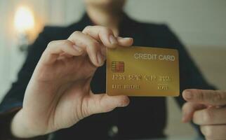 mãos de mulher segurando e usando cartão de crédito para compras online. foto