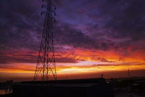 Alto Voltagem poder linha torre com lindo céu às pôr do sol, estoque foto
