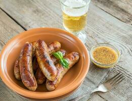 salsichas grelhadas com copo de cerveja foto