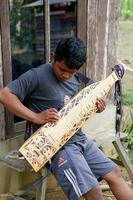 kuaro Kalimantan timur, Indonésia 21 Junho 2023. uma homem jogando uma tradicional Kalimantan dayak musical instrumento foto