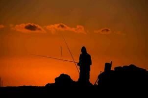 pescaria sobre a pôr do sol foto