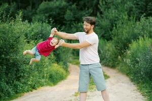 feliz e doce momentos do uma verão andar dentro a parque do uma pai e uma pequeno filho foto