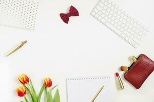 dia dos namorados Área de Trabalho fundo com vermelho tulipa, caderno, Cosmético, caneta. dia dos namorados dia cumprimento cartão. fêmea blogueiro ambiente de trabalho. topo Visão com cópia de espaço foto